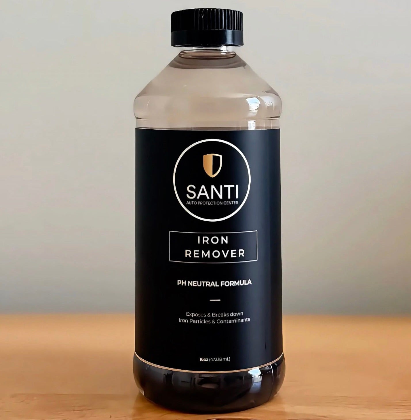 A 5L clear plastic bottle of SANTI Iron Remover pH Neutral Formula with a black cap and black label, sitting on a wooden surface against a neutral beige background.