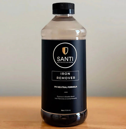 A 5L clear plastic bottle of SANTI Iron Remover pH Neutral Formula with a black cap and black label, sitting on a wooden surface against a neutral beige background.
